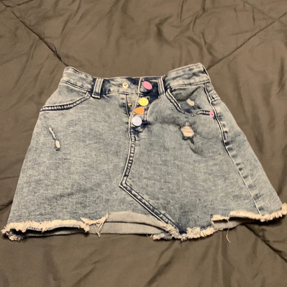 Denim skirts with rainbow pastel buttons.